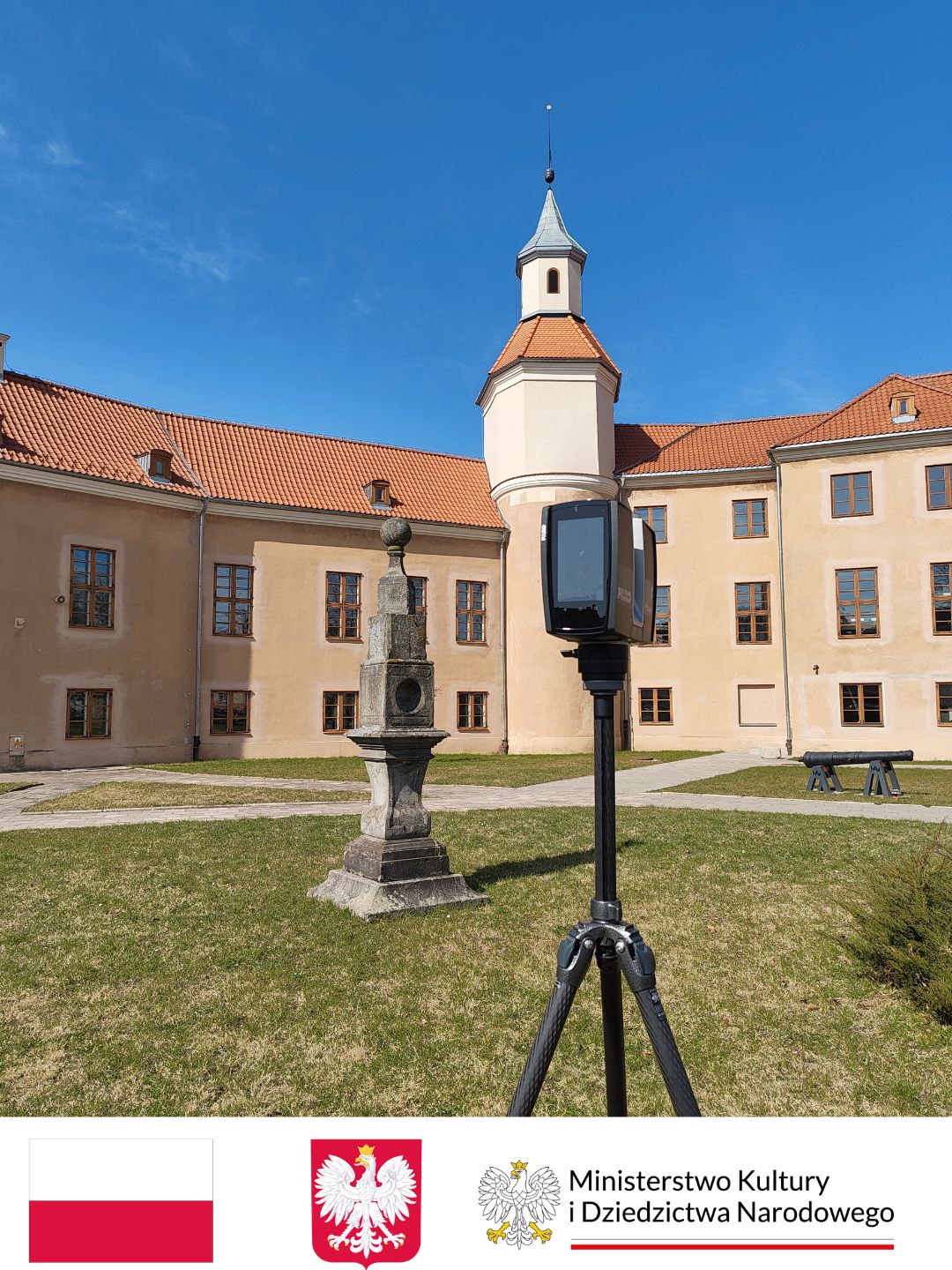 Na pierszym planie skaner laserowy z napisem FARO w tle rzeźba z kamienia, dalej fragment dużego budynku z wieżyczką, wyglądającego jak pałac w kolorze beżowym.